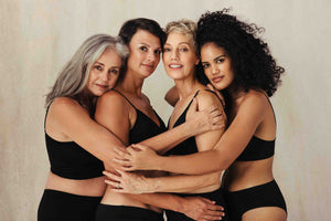 Four mature women in black underwear hugging in support